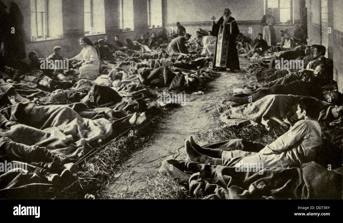 Guerra mondiale 1. Soldati russi feriti a Dunajec. Un vecchio sacerdote della chiesa greco-cattolica a confortare i feriti e morire Foto Stock