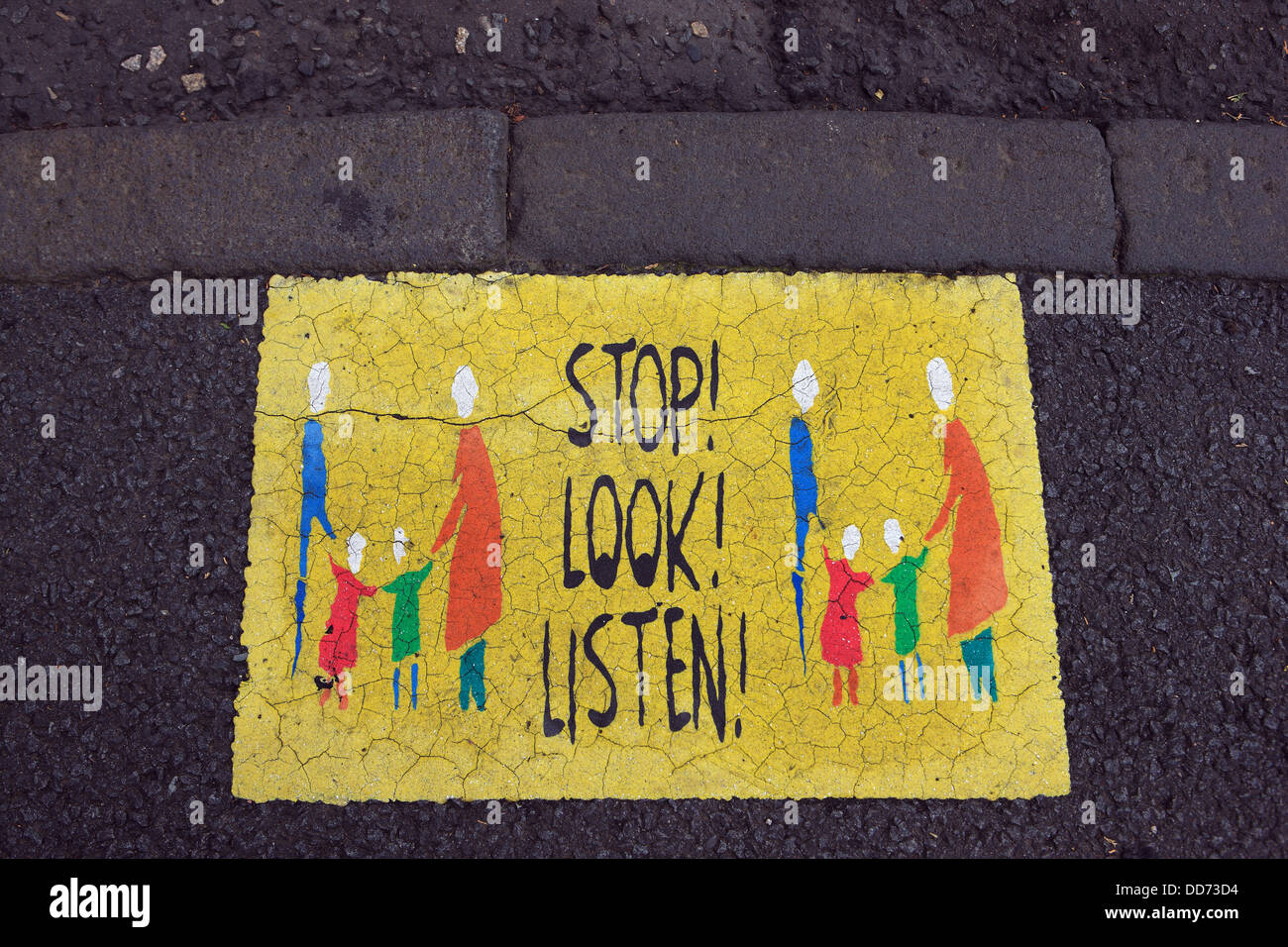 Smettere di guardare e ascoltare il segno, rivolto a bambini, sul marciapiede nel villaggio scozzese di Aberdour in Fife Scozia Scotland Foto Stock