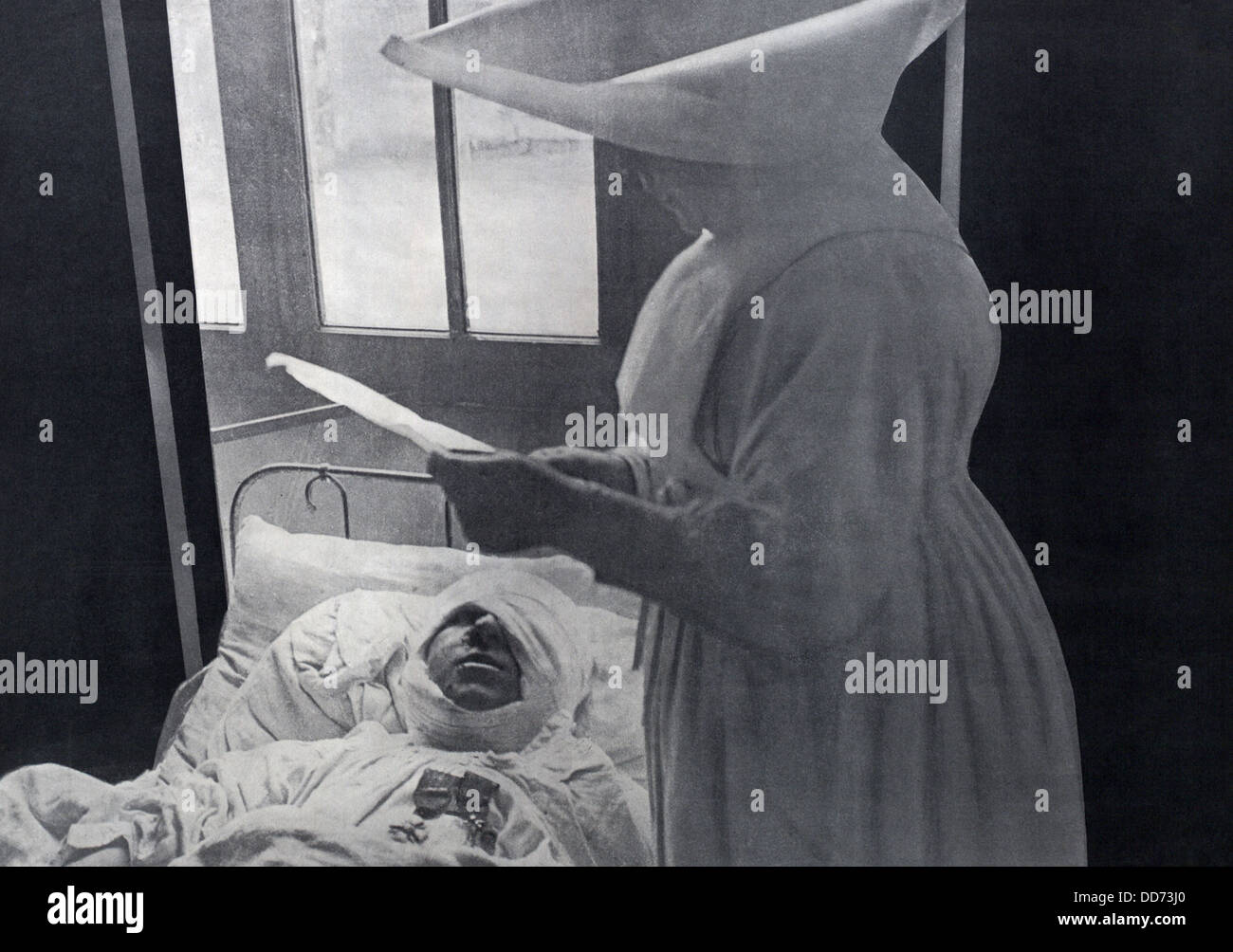 Il francese nun frequentando un WW1 soldato ferito decorata nel suo letto di ospedale. 1916. Indossa il suo due medaglie come pure una massiccia Foto Stock