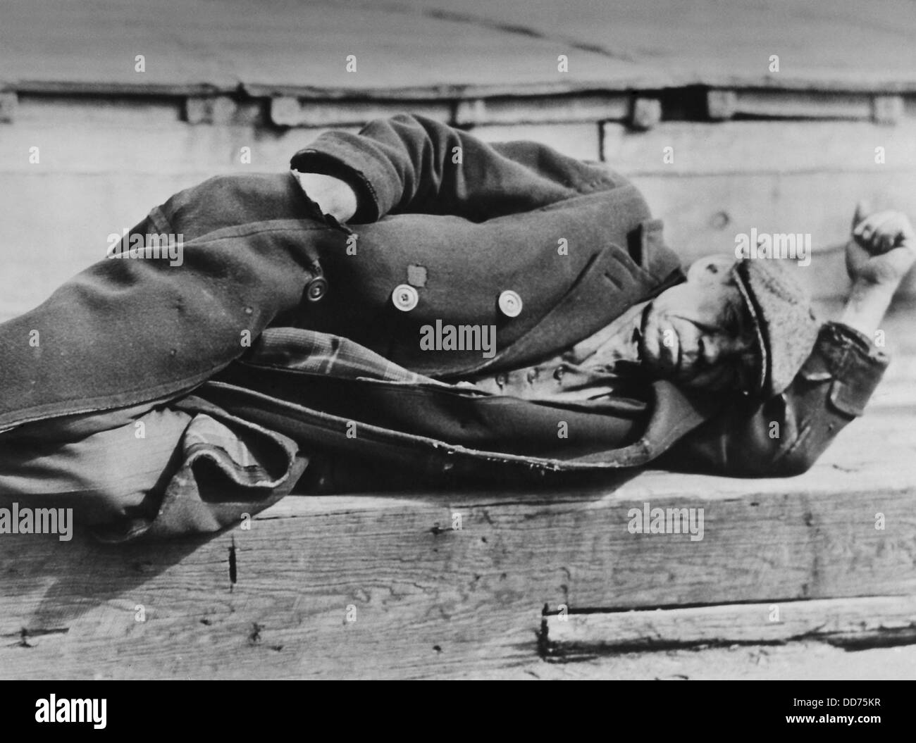 Uomo dorme sul dock di NYC, ca. 1930-31, da Lewis Hine. Indossa un pezzo tre tuta sotto il suo sovrarivestimento usurati, indicando il suo Foto Stock
