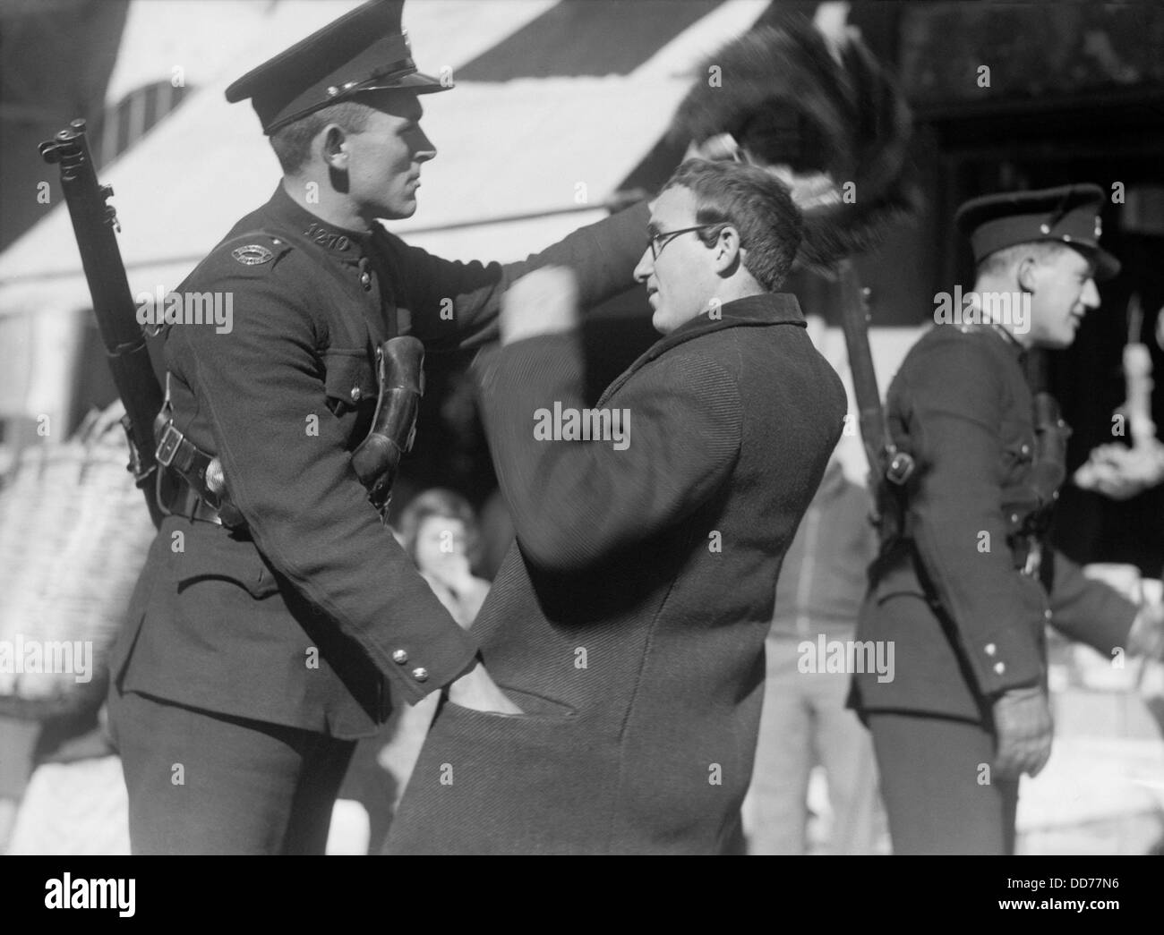 Polizia britannica ricerca ebreo ortodosso per i bracci in Gerusalemme, 1938. Il funzionario ispeziona il 'shtreimel', il cappello di pelliccia indossata da Foto Stock