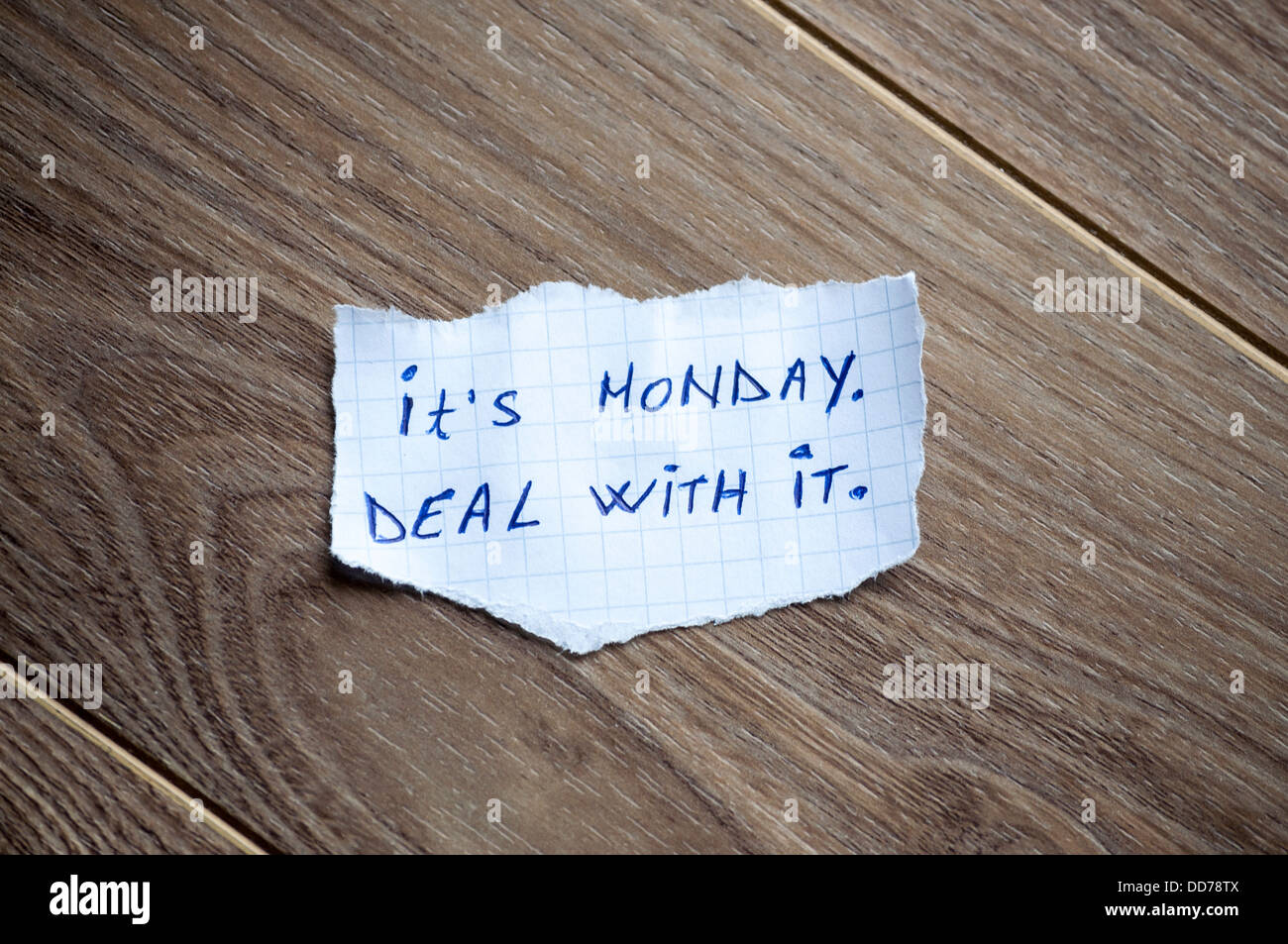 Si tratta di lunedì. Trattare con esso scritto sul pezzo di carta su un sfondo di legno. Foto Stock