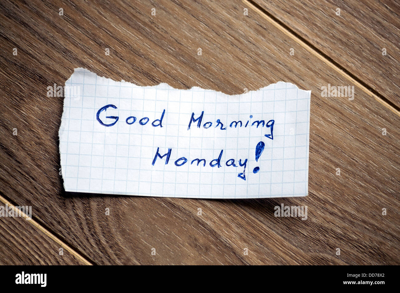 Buona mattina lunedì scritto sul pezzo di carta su un sfondo di legno. Foto Stock