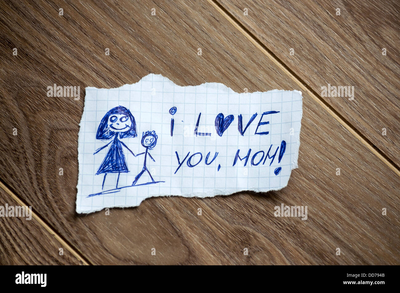 Ti amo, mom scritto sul pezzo di carta su un sfondo di legno Foto Stock