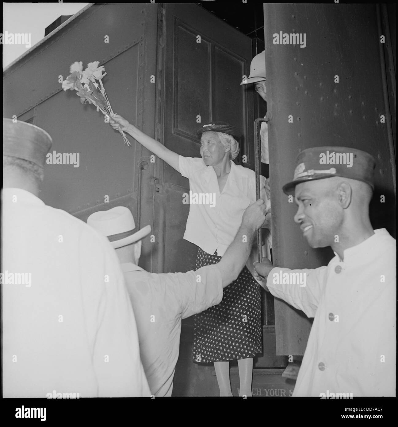 Un'anziana donna Issei ondeggia un mucchio di fiori durante la chiusura del Jerome Relocation Center a Denson, Arkansas. Il centro di trasferimento fu uno dei campi di internamento durante la seconda guerra mondiale Foto Stock Un'anziana donna Issei ondeggia un mucchio di fiori durante la chiusura del Jerome Relocation Center a Denson, Arkansas. Il centro di trasferimento fu uno dei campi di internamento durante la seconda guerra mondiale Foto Stock