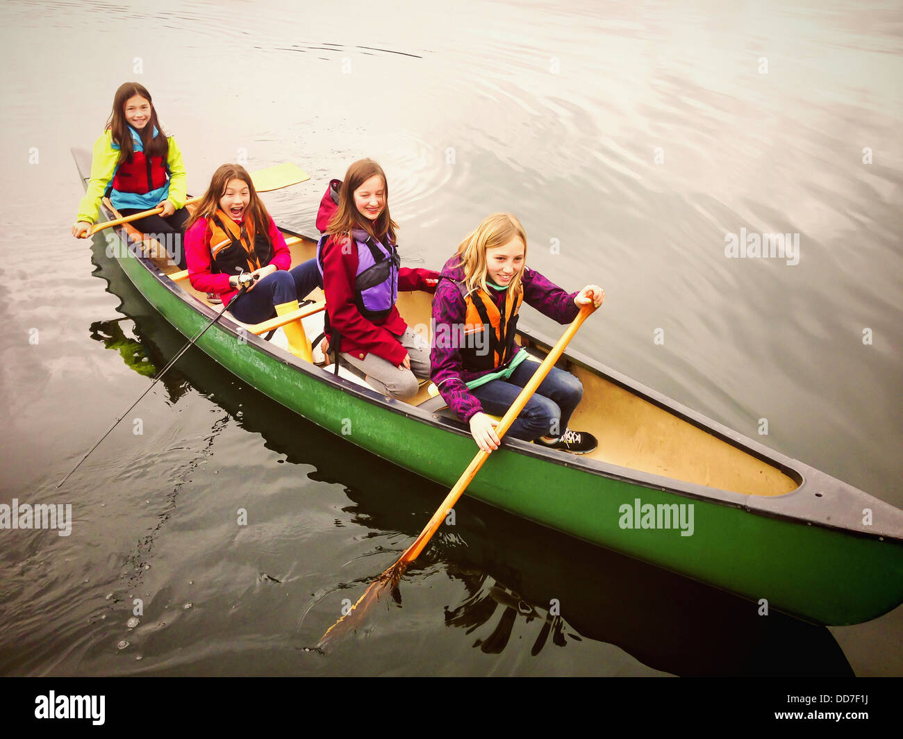 Le ragazze di canottaggio in canoa ancora lago rurale Foto Stock