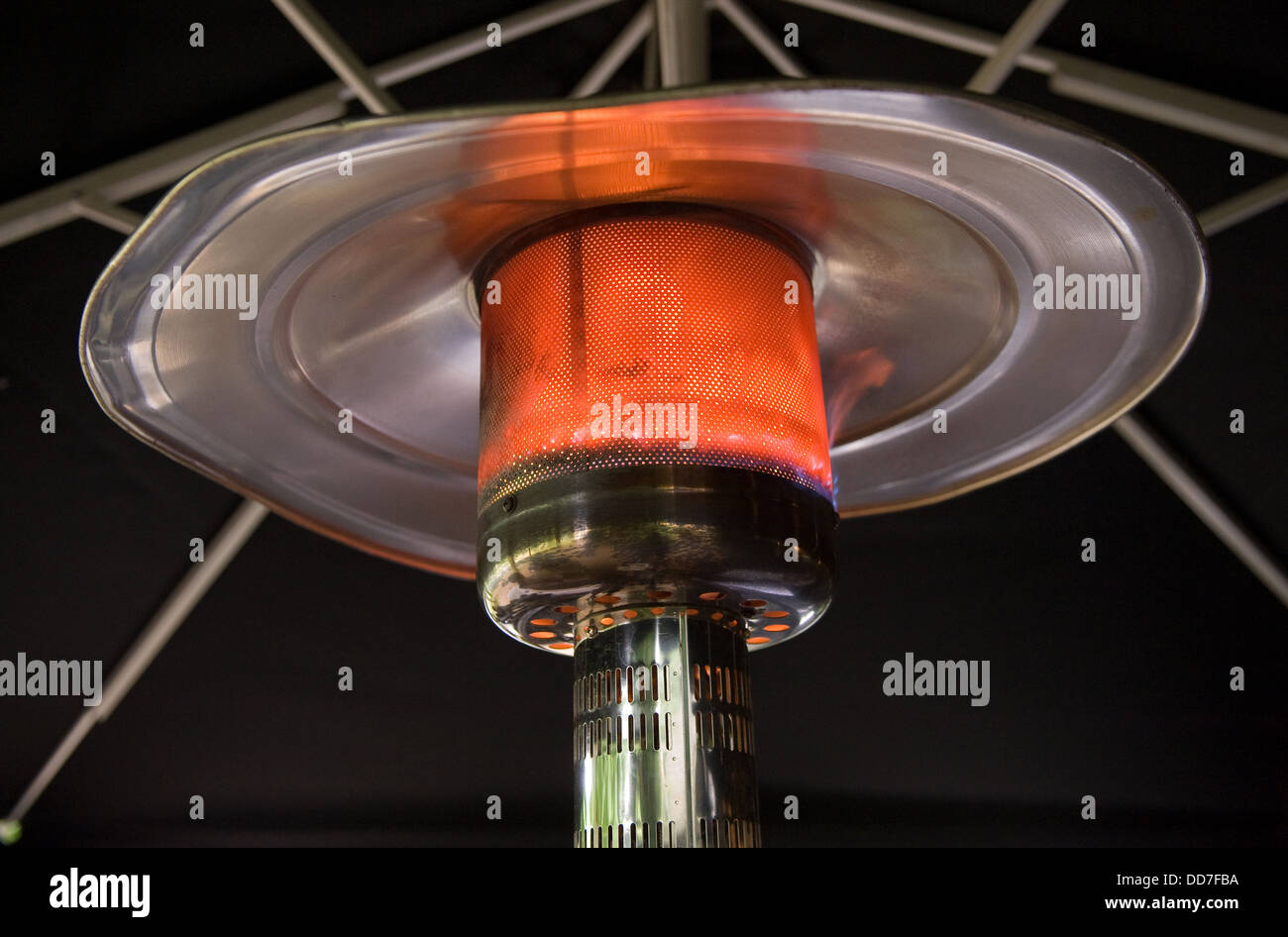 Un riscaldatore di masterizzazione sotto un grande ombrellone Foto Stock