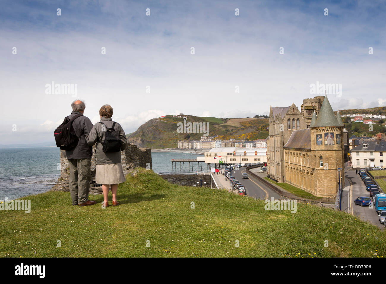 Regno Unito, Galles Ceredigion, Aberystwyth, coppia di mezza età sul tumulo di castello affacciato sul primo edificio universitario Foto Stock