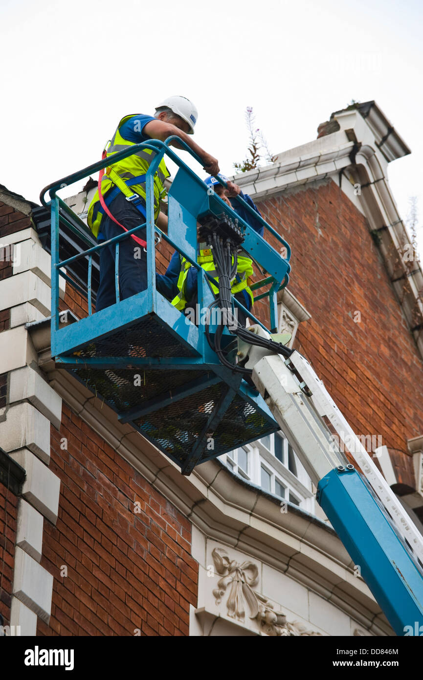 Imprenditori in alto la piattaforma di accesso rendere sicuro un edificio dopo essere stata danneggiata da un fulmine nella città di York England Regno Unito Foto Stock