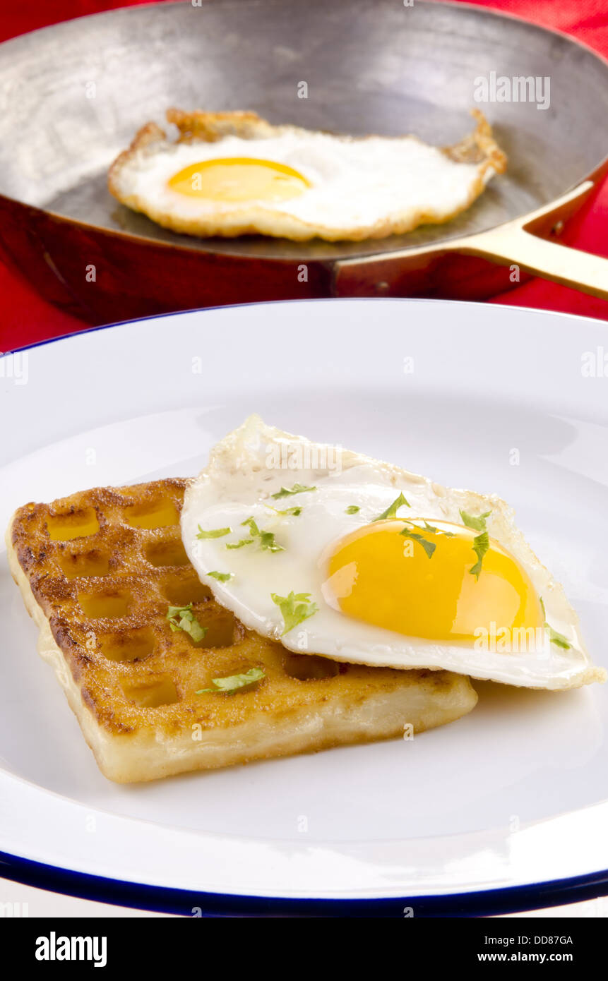 Cialda di patata con uovo fritto su una piastra Foto Stock