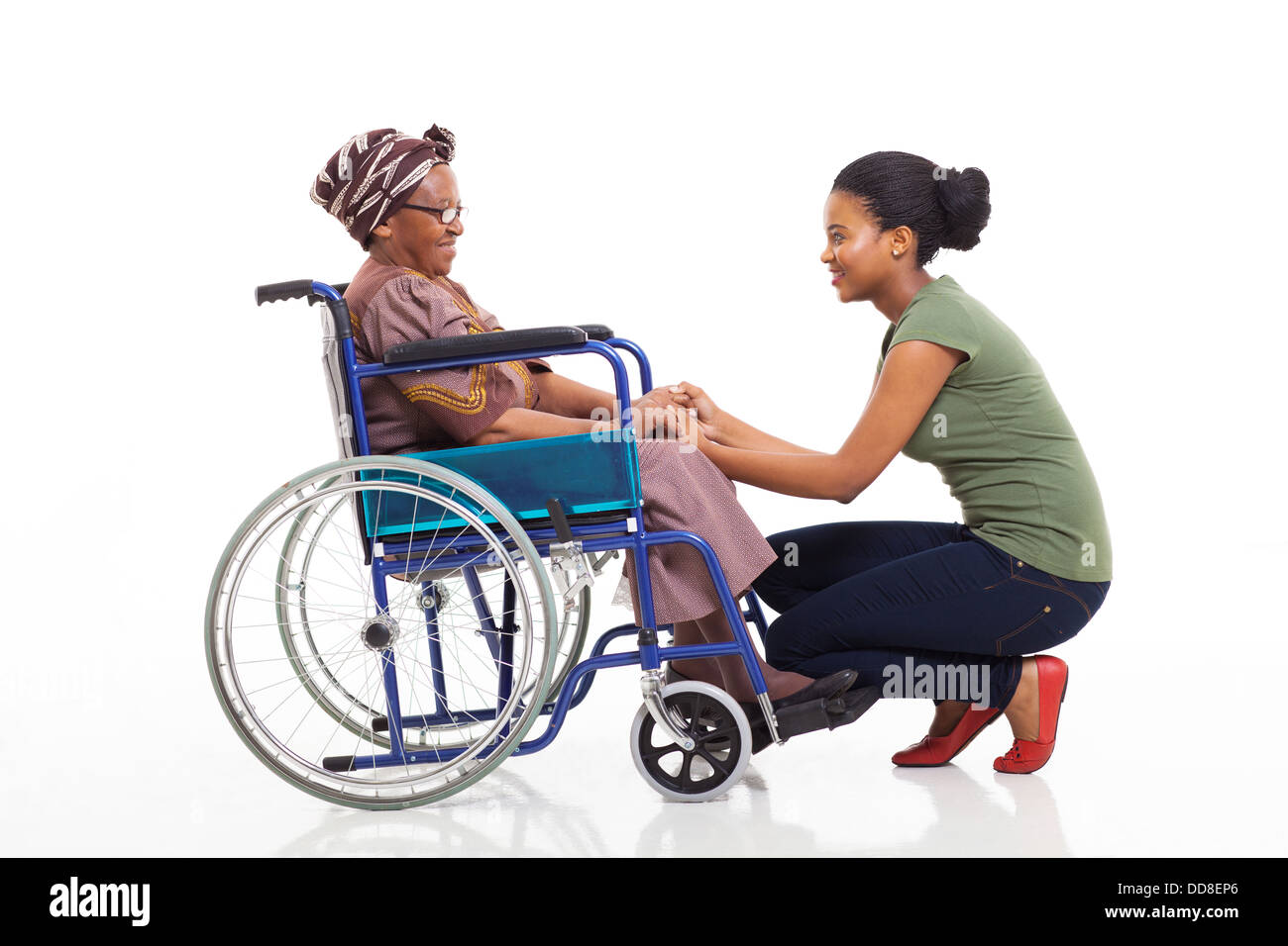 Amorevole figlia africana parla di disabili madre senior su sfondo bianco Foto Stock