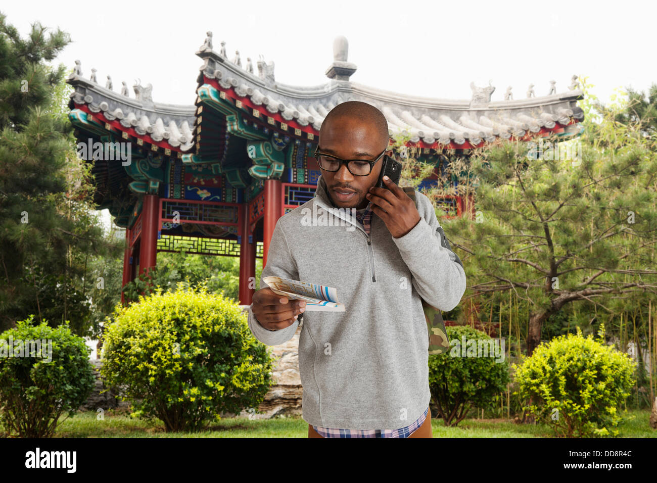 Uomo nero mappa di lettura su una strada di città, Beijing, Pechino, Cina Foto Stock