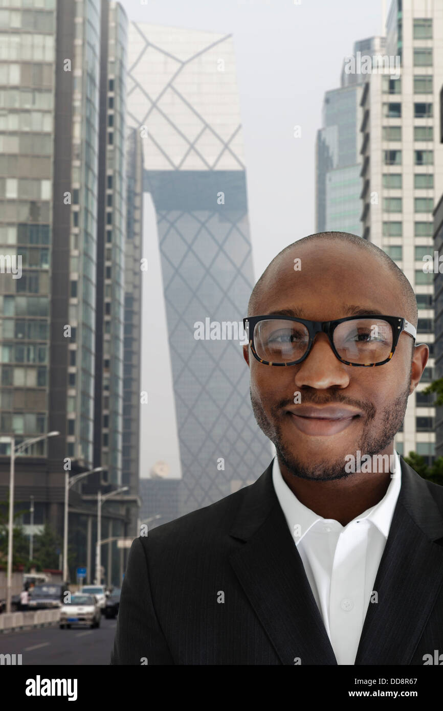 Imprenditore nero sorridente su una strada di città Foto Stock