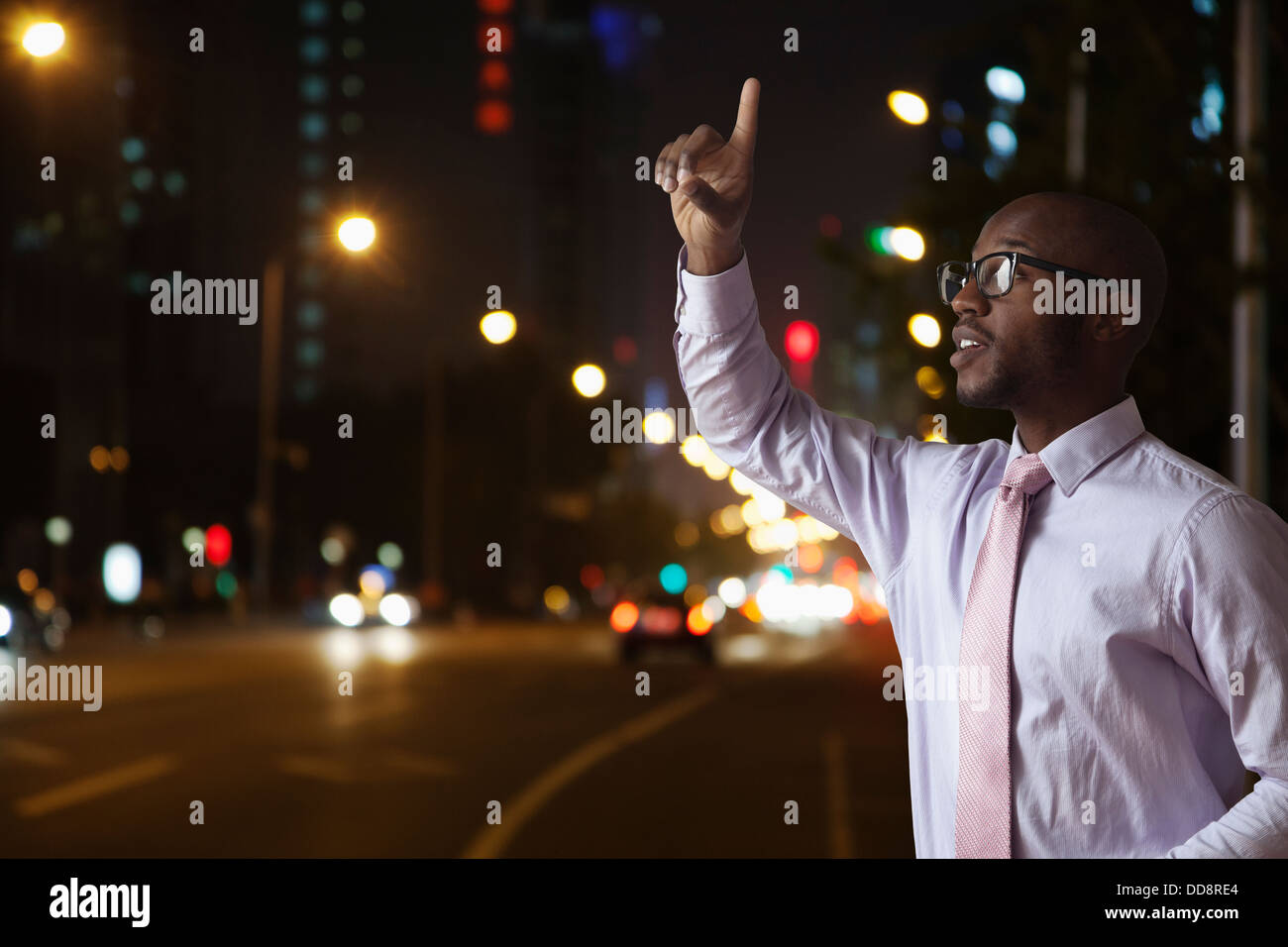 Imprenditore nero salutando taxi sulla strada di città Foto Stock