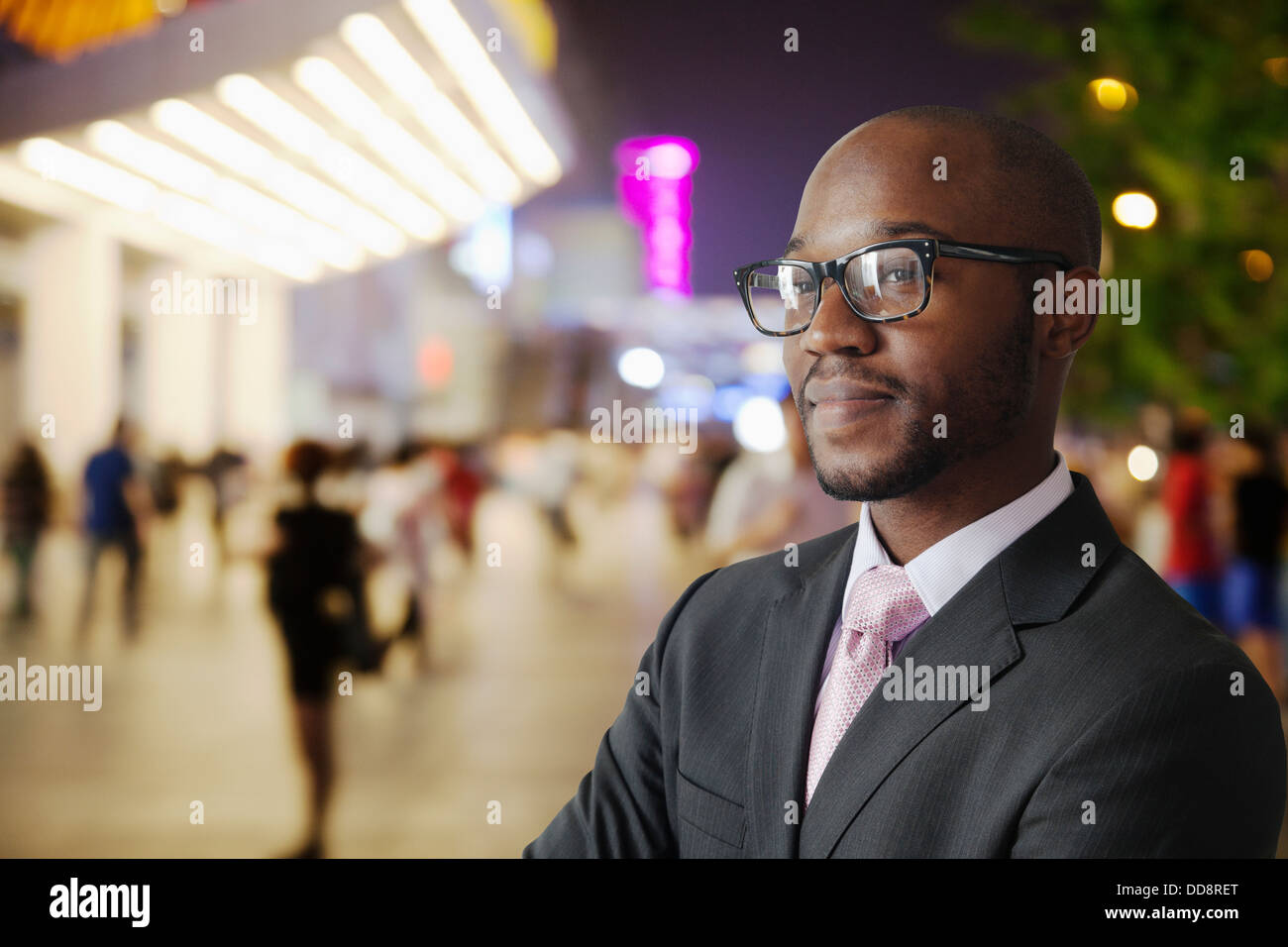 Imprenditore nero sorridente su una strada di città Foto Stock