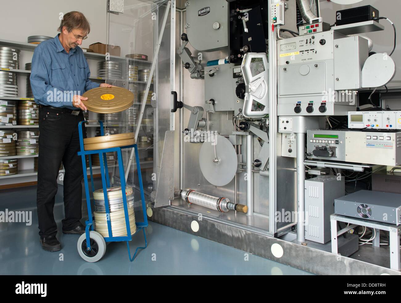 Il direttore del dipartimento per la pellicola di restauro e conservazione , Egbert Koppe, lattine di pellicola in una stanza di deposito presso la Repubblica Federale Tedesca archivio di film in Hoppegarten, Germania, 12 agosto 2013. Koppe è preoccupato per la desolata condizione di alcuni dei depositi di film che sono distribuite tra diverse strutture in diverse posizioni. I negoziati sono in corso da anni per quanto riguarda un nuovo impianto centralizzato per la pellicola di conservazione e archiviazione in Hoppegarten vicino a Berlino. Foto: Patrick Pleul Foto Stock