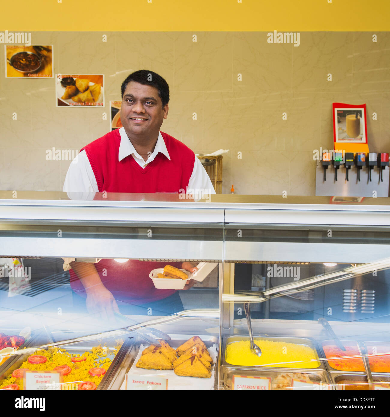 Commerciante indiano dietro il ristorante counter Foto Stock