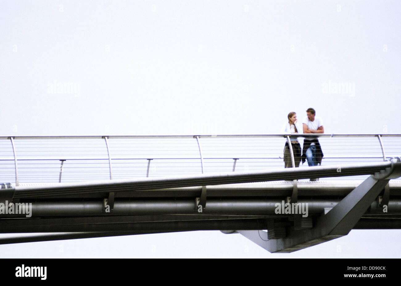 Giovane solo in cima pf ponte pedonale oltre il Tamigi. Londra. Inghilterra Foto Stock