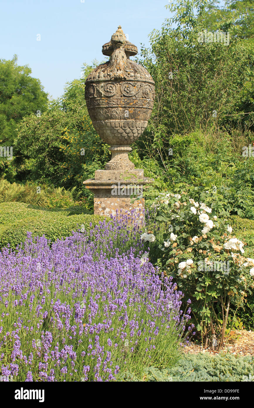 Enorme urna in pietra con lavanda e rose bianche nel giardino di Petworth House, West Sussex, Regno Unito Foto Stock
