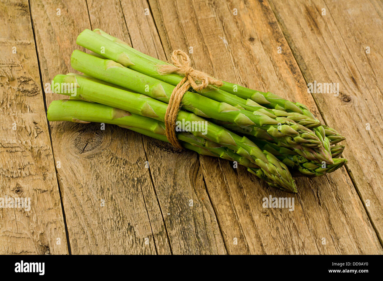Mazzetto di asparagi un premio di ortaggi di stagione su un rustico rurale antico tavolo di legno impostazione superiore Foto Stock