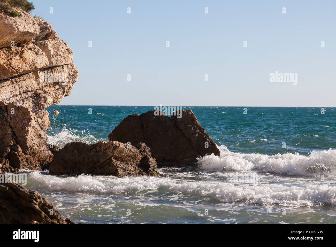 Onde che si infrangono sulla scogliera di roccia Foto Stock