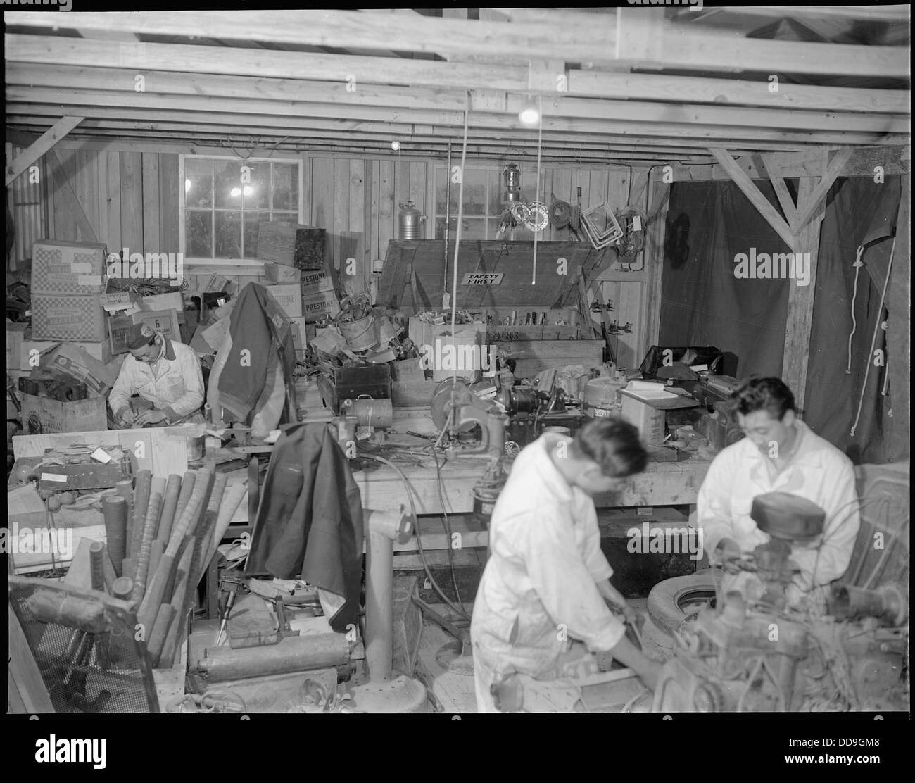 Presso il Jerome Relocation Center di Denson, Arkansas, le riparazioni dei motori sono in corso in un garage temporaneo, parte delle attività quotidiane del centro. Foto Stock