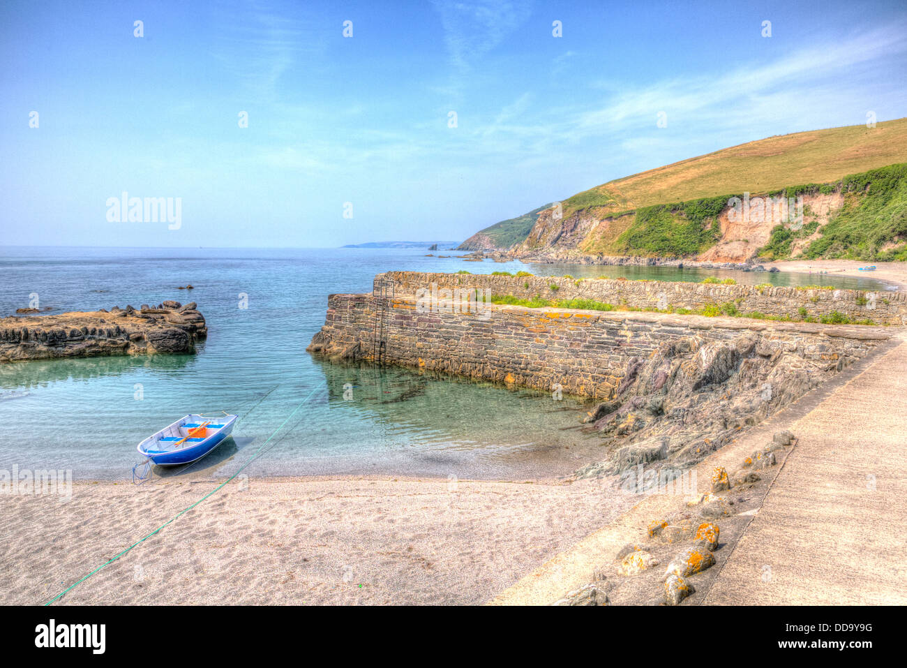 Unico dinghy in legno ormeggiata nel porto di mare azzurro e limpido Portwrinkle Cornwall in HDR in Inghilterra Foto Stock