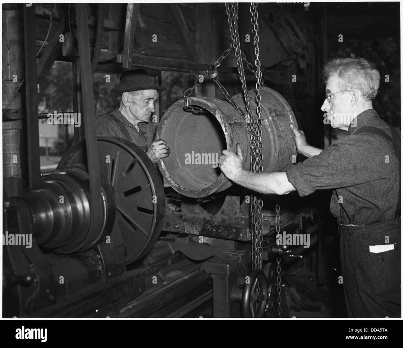 Questi due uomini hanno lavorato 15 ore al giorno, 7 giorni alla settimana, e hanno condotto 18,000 flange in acciaio per attrezzature da guerra in 18 mesi. - 196377 Foto Stock