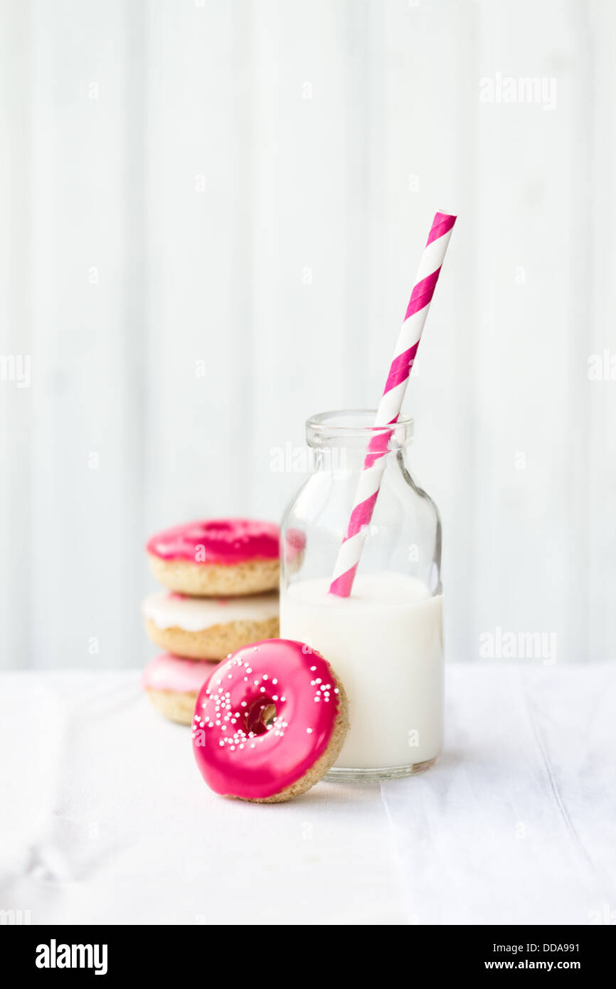 Pila di mini ciambelle servita con latte Foto Stock
