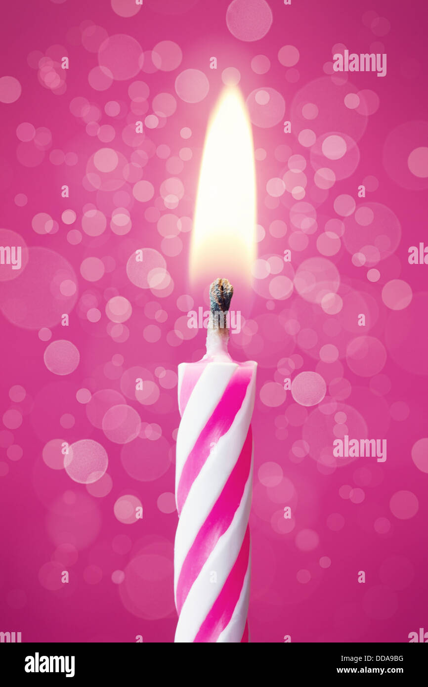 Torta di compleanno candela contro un sfondo rosa Foto Stock