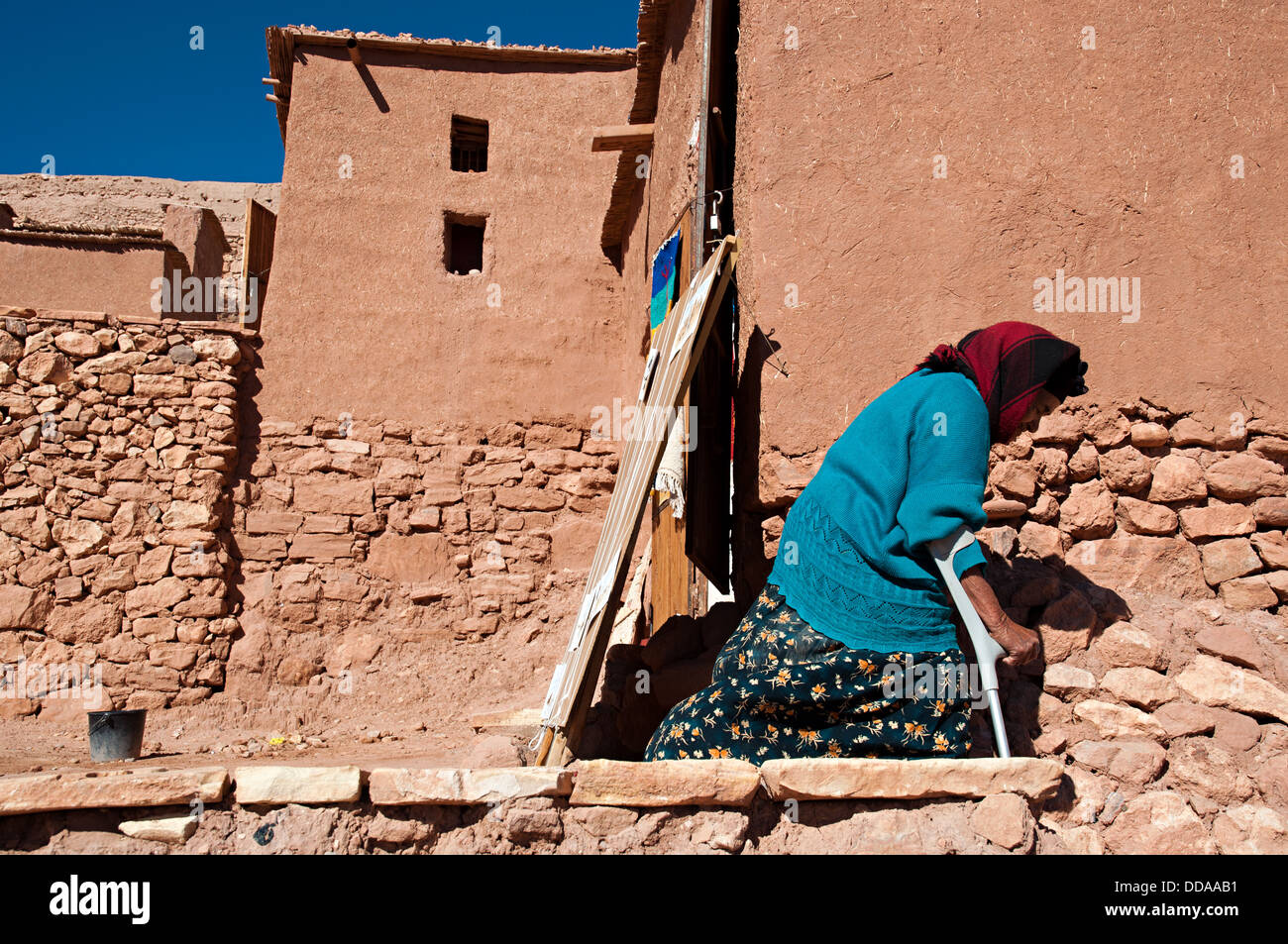 Il sambuco donna camminare per le strade di Ait Benhaddou kasbah, Marocco Foto Stock
