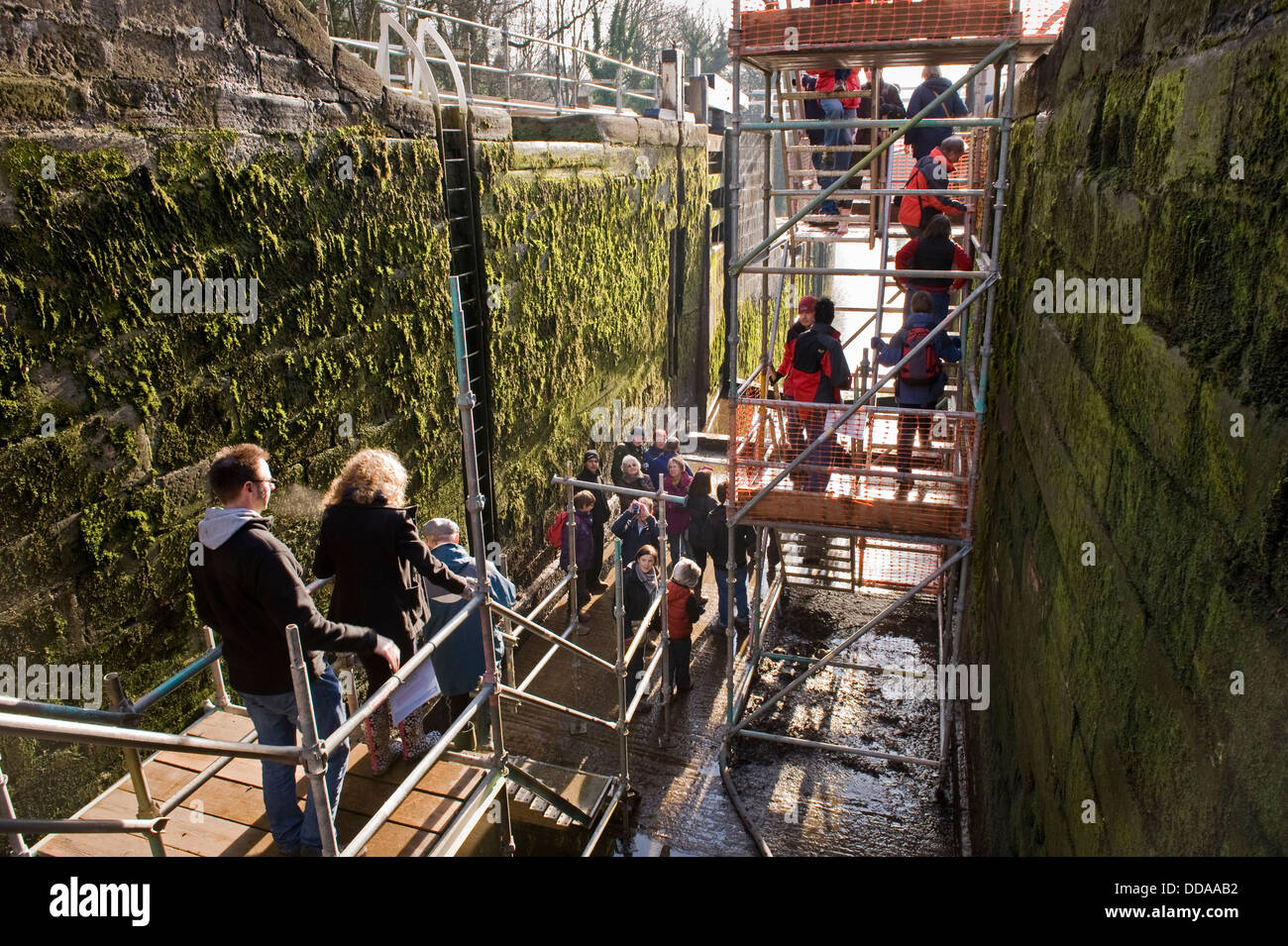 Le persone all'interno di un blocco drenato camera, walking round & guardando a lavori di ristrutturazione - open day, Bingley dell aumento di cinque serrature, West Yorkshire, Inghilterra, Regno Unito. Foto Stock