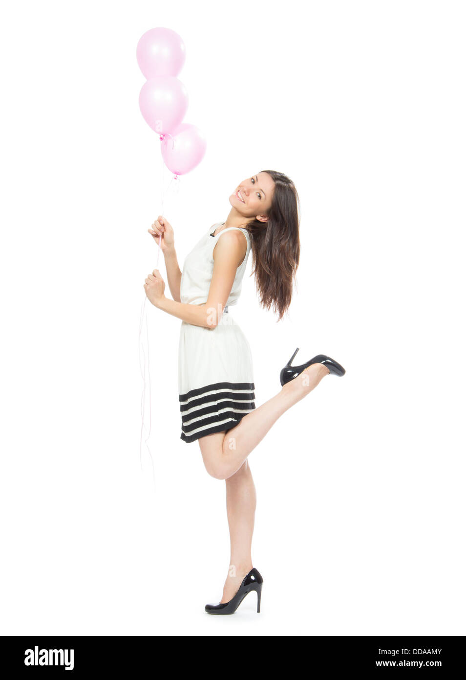 Giovane ragazza felice con palloncini come un regalo per la festa di compleanno sorridente e guardando l'angolo su sfondo bianco Foto Stock