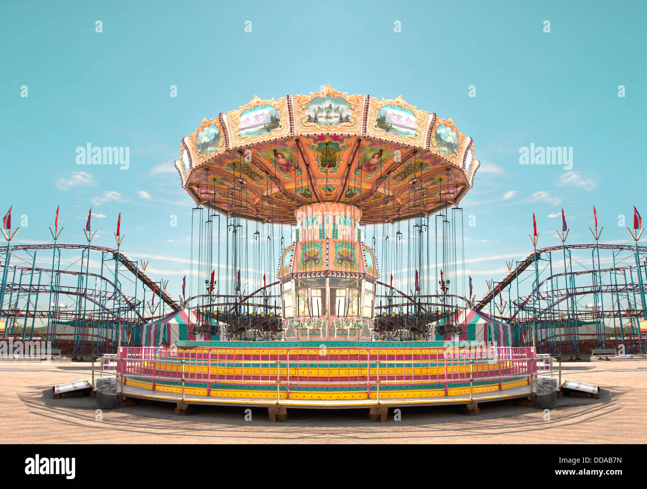 Giostra con altalene e roller coaster in background ad una fiera Foto Stock