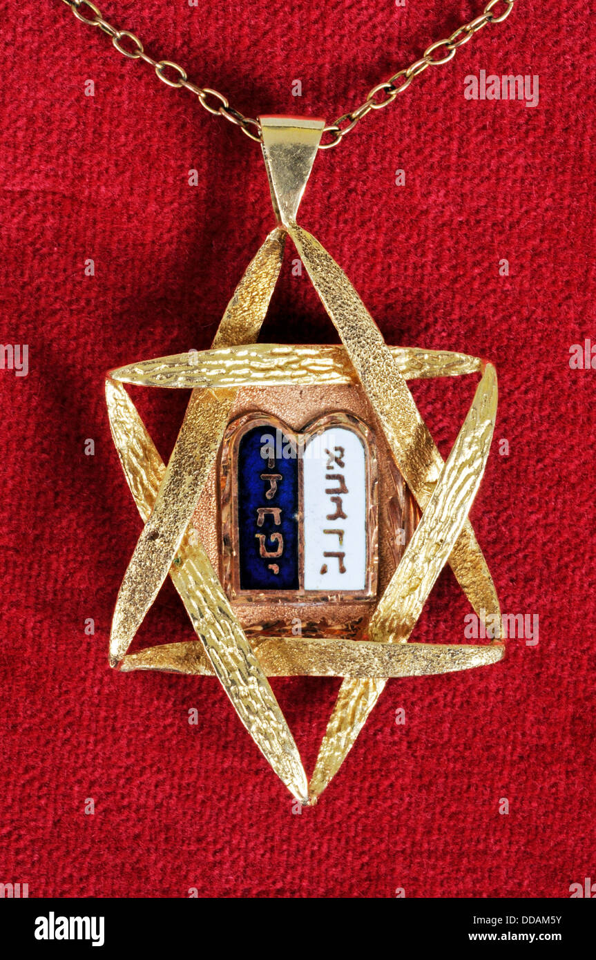 Stella di Davide e dieci comandamenti, pendente contro uno sfondo di colore rosso. Foto Stock