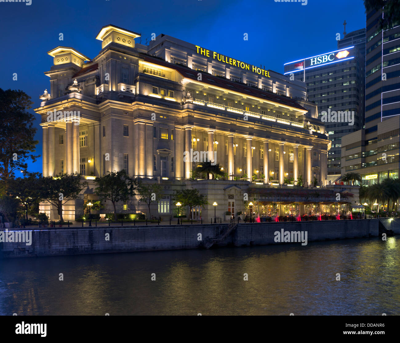 Dh Fiume Singapore DOWNTOWN CORE SINGAPORE Il Fullerton Hotel occupa un edificio di sera illuminate di luce alberghi Foto Stock