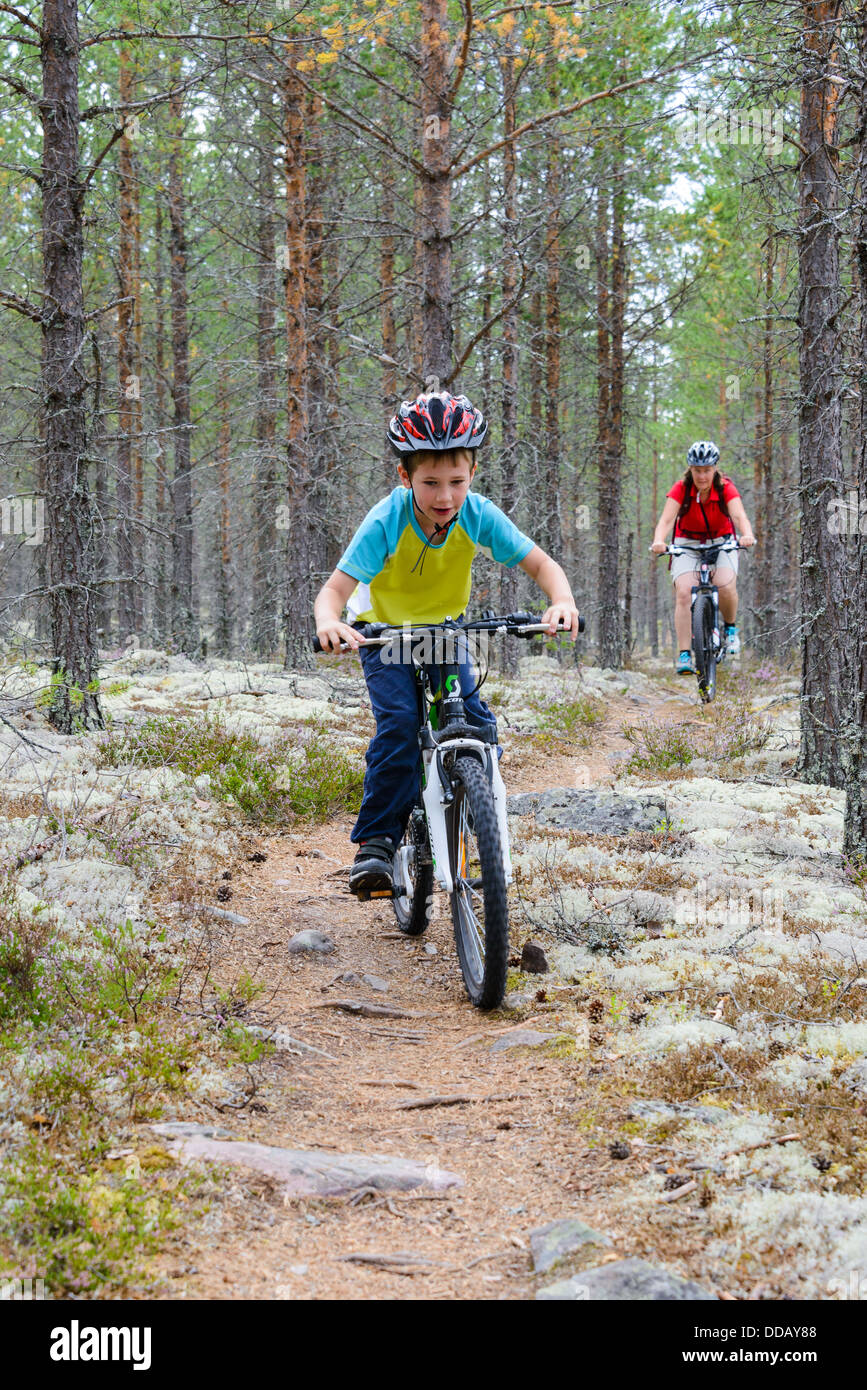 Ragazzo e madre escursioni in bicicletta sul percorso attraverso i boschi, Rörbäcksnäs, Dalarna, Svezia Foto Stock