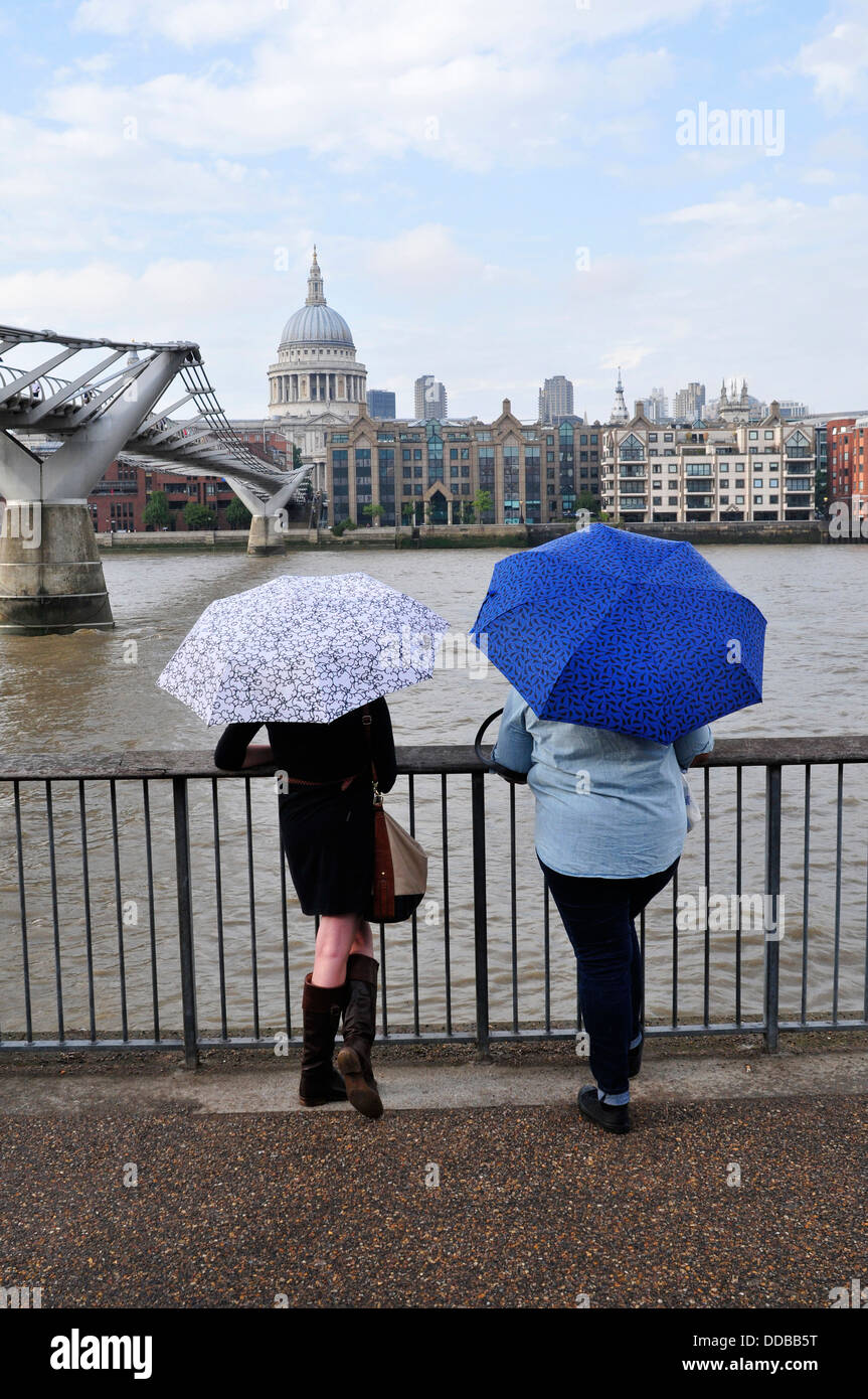 Una vista posteriore di due donne con ombrelloni, London, Regno Unito Foto Stock Una vista posteriore di due donne con ombrelloni, London, Regno Unito Foto Stock