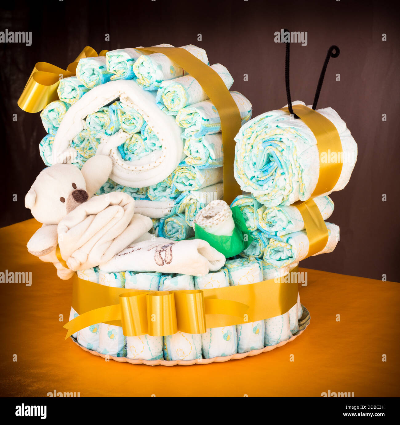 Pannolini arrotolato per creare un pannolino lumaca torta con vestiti del  bambino e del nastro Foto stock - Alamy