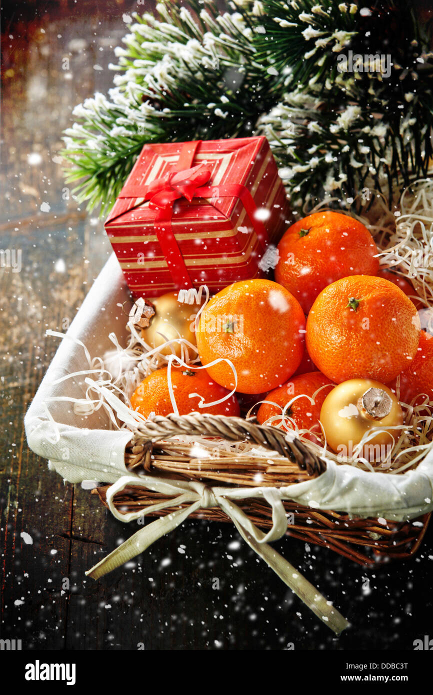 I mandarini nel cestino con il regalo di Natale e il ramo di albero Foto Stock