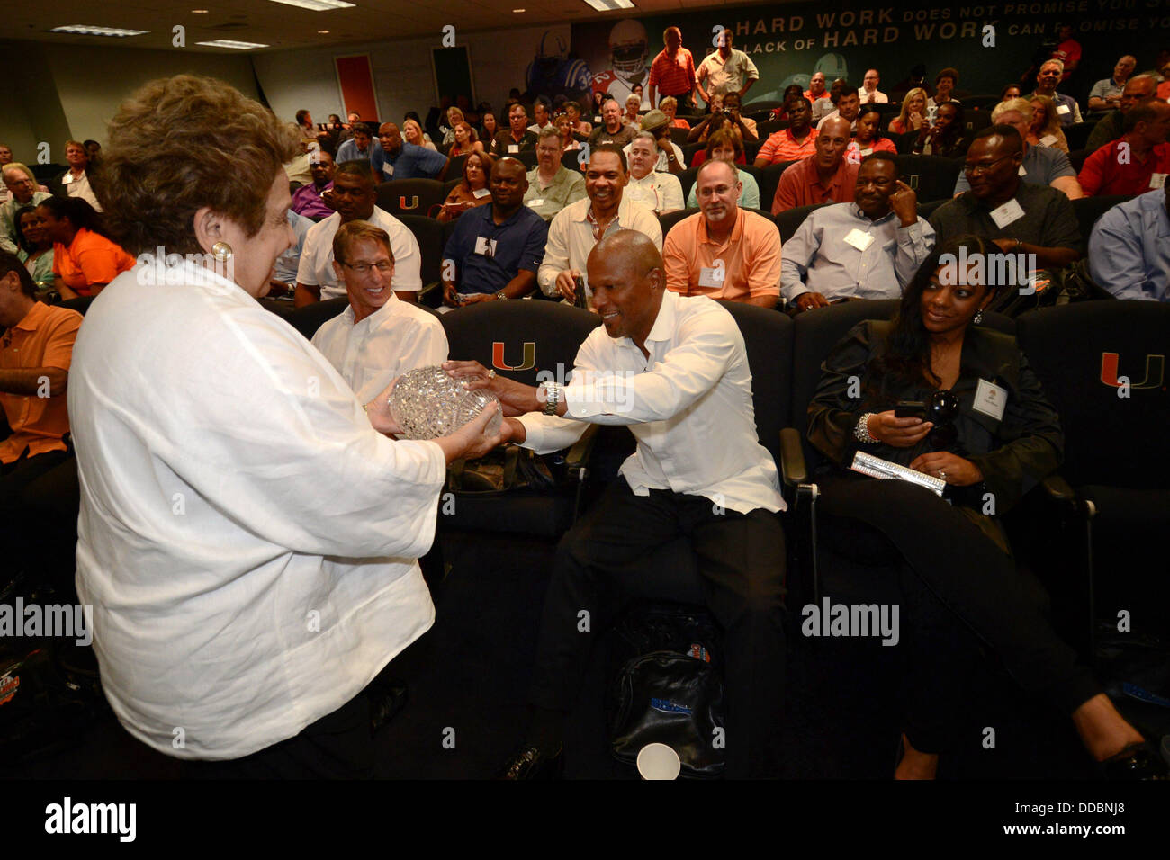 Agosto 29, 2013: ex università di Miami wide receiver Brian blade e University of Miami presidente Donna Shalala con il Campionato trofeo durante un evento di onorare il trentesimo anniversario del campionato nazionale di squadra a Hecht Centro Atletico sul campus della University of Miami in Coral Gables, Florida. La scuola ha appena ricevuto il trofeo dalla American Allenatori di calcio di associazione. Foto Stock