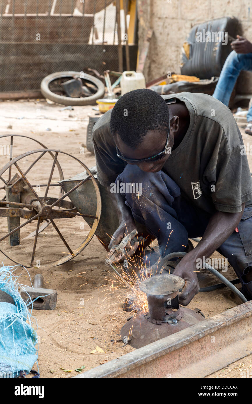 Saldatore nel lavoro del fabbro Shop Dove ripuntatori sono realizzati, vicino a Kaolack, Senegal. Foto Stock