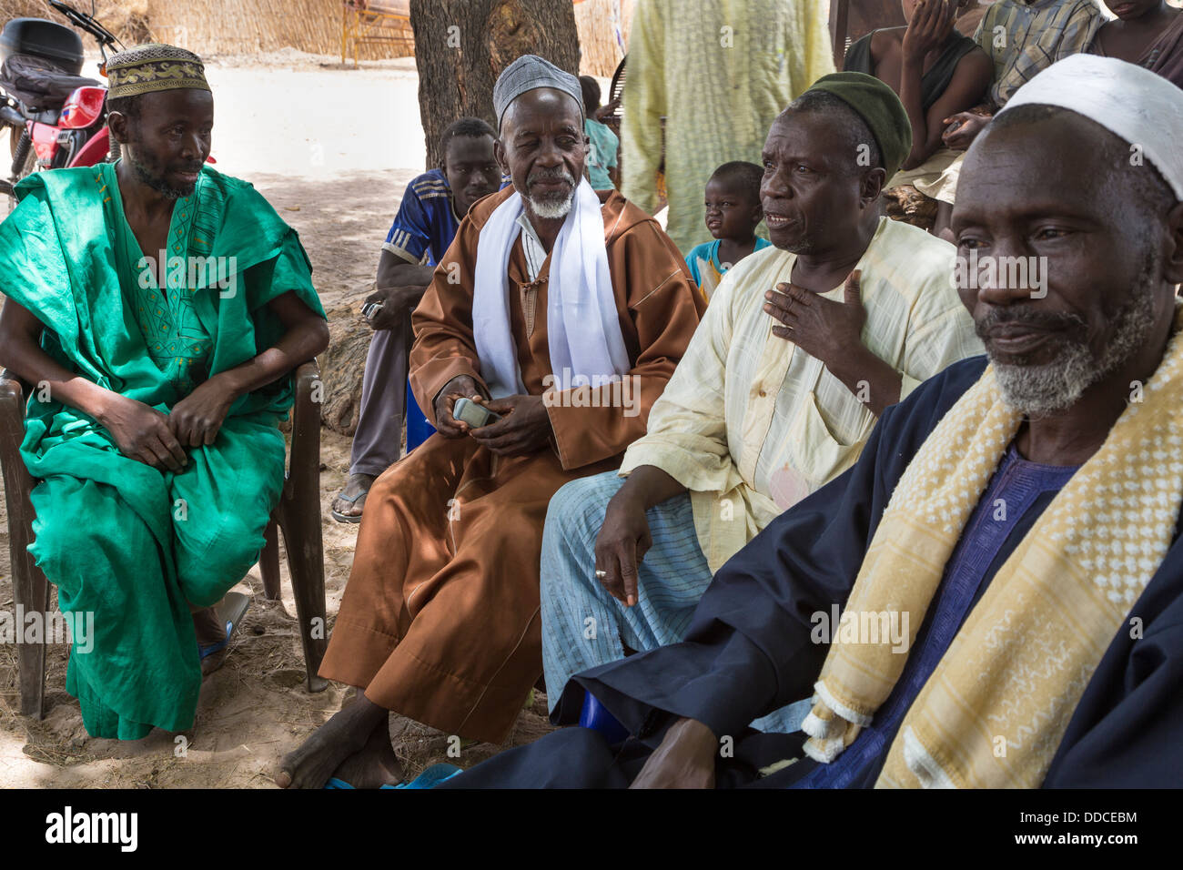 Il Wolof-senegalese che parla agli uomini per partecipare a una riunione di microcredito a Djilor, un Wolof Village, vicino a Kaolack, Senegal. Foto Stock