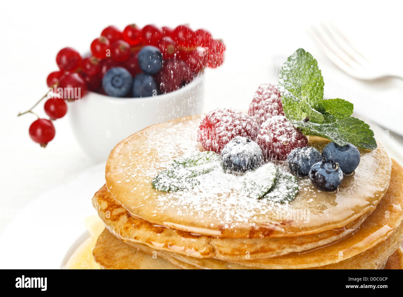 Pila di deliziose frittelle fatte a mano e rabboccato con miele, lamponi e mirtilli Foto Stock Pila di deliziose frittelle fatte a mano e rabboccato con miele, lamponi e mirtilli Foto Stock
