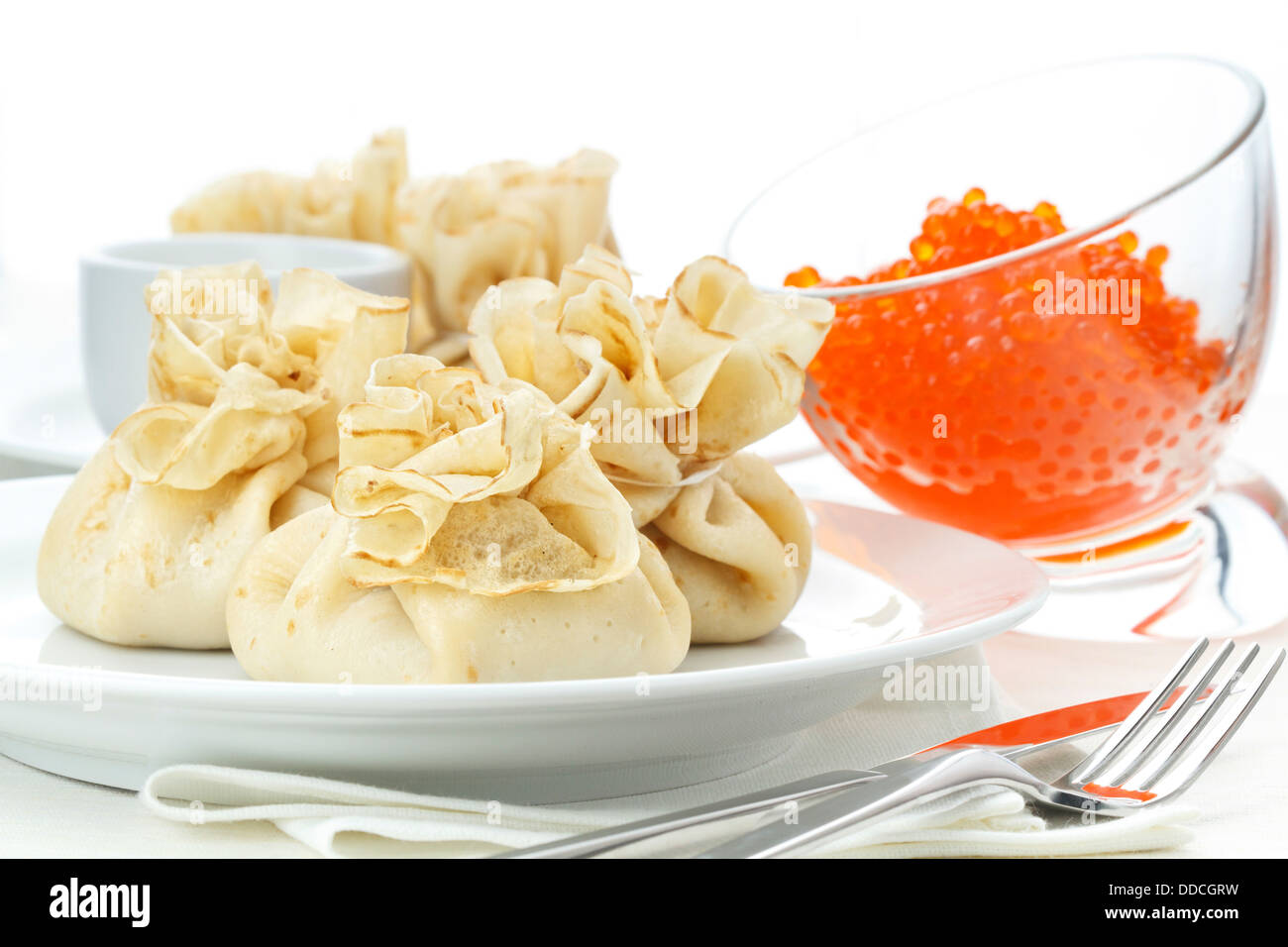 Pancake buste con caviale rosso su sfondo bianco Foto Stock