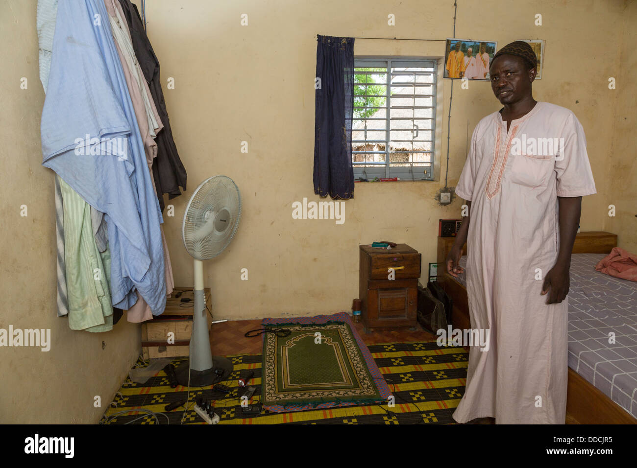 L'agricoltore senegalese e la sua ventola. Un tetto con pannello solare alimenta questa ventola, portando conforto per la camera da letto. Bijam, Senegal. Foto Stock