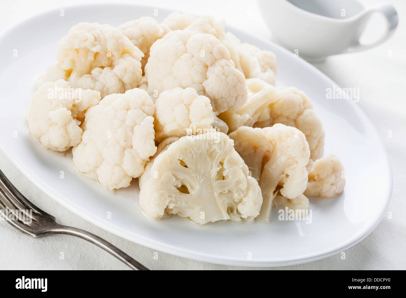 Cavolfiore al vapore con salsa sulla piastra bianca Foto Stock