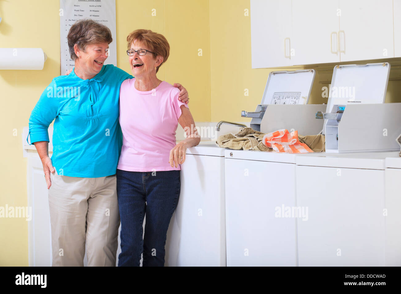 Senior donne ridere in una sala lavanderia Foto Stock
