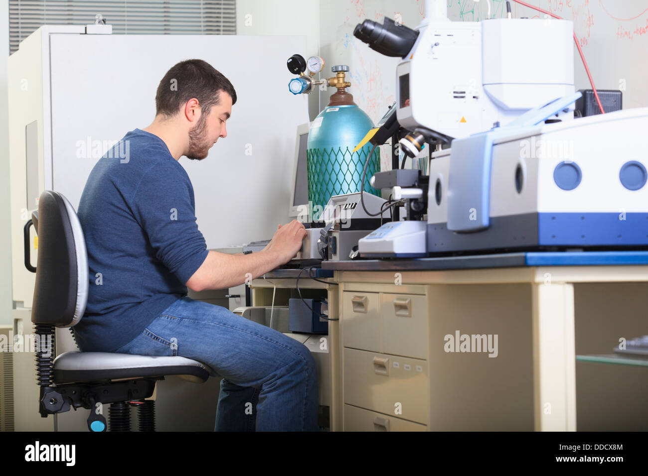 Studente di ingegneria lettura schermata di analisi chimica attrezzature in un laboratorio Foto Stock