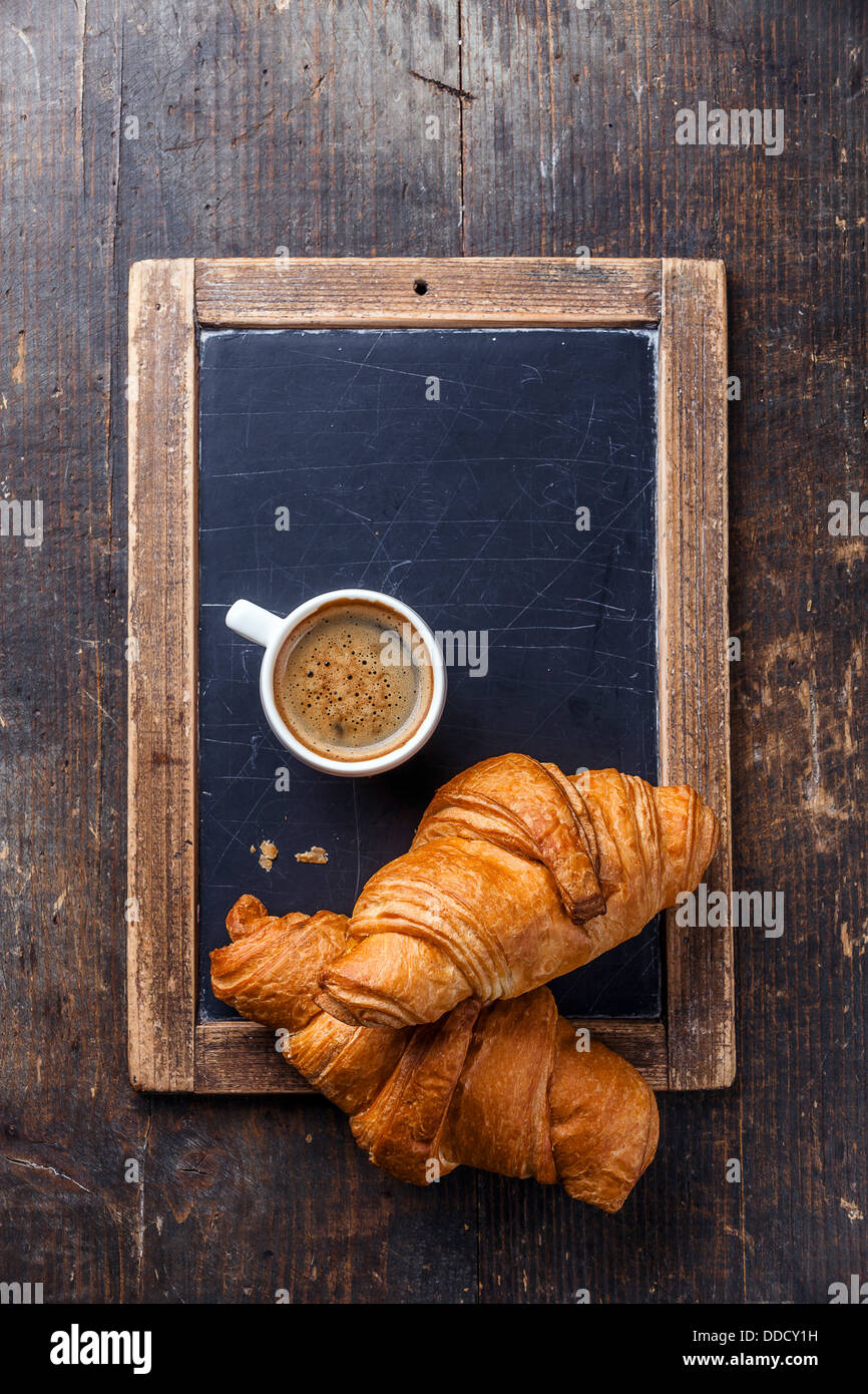 Tazza di caffè e croissant su ardesia vintage chalk board Foto Stock